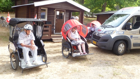 3 rickshaws med passagerer foran en campinghytte